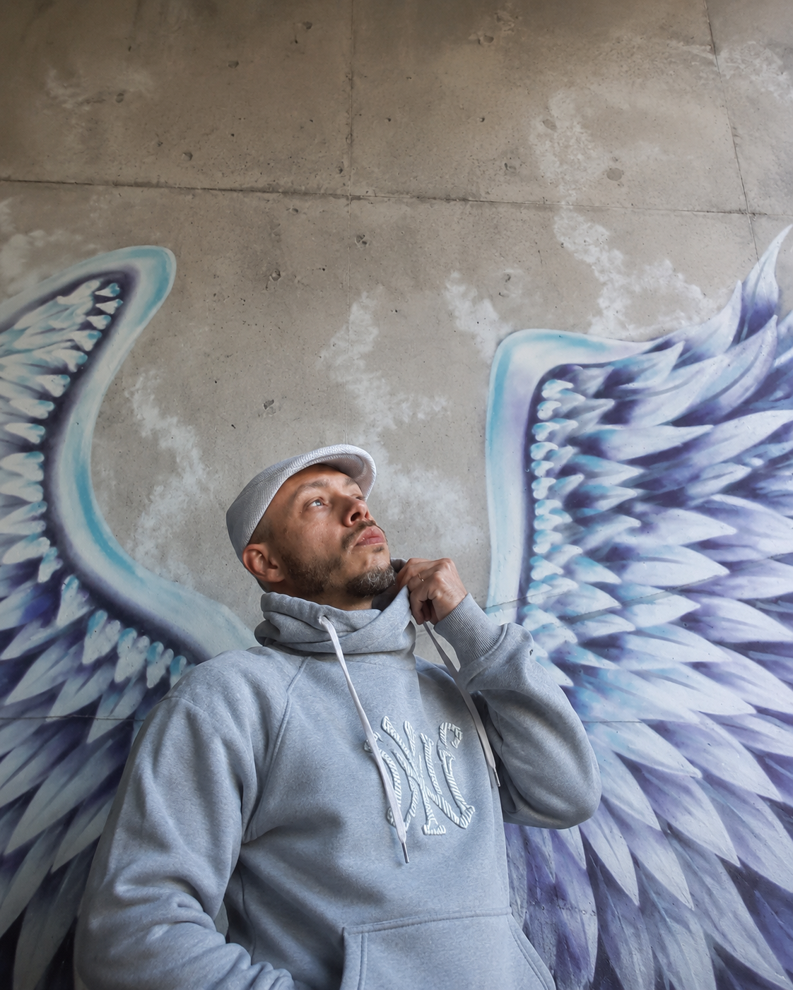 Portrait of Yaakov83 in front of angel wings mural